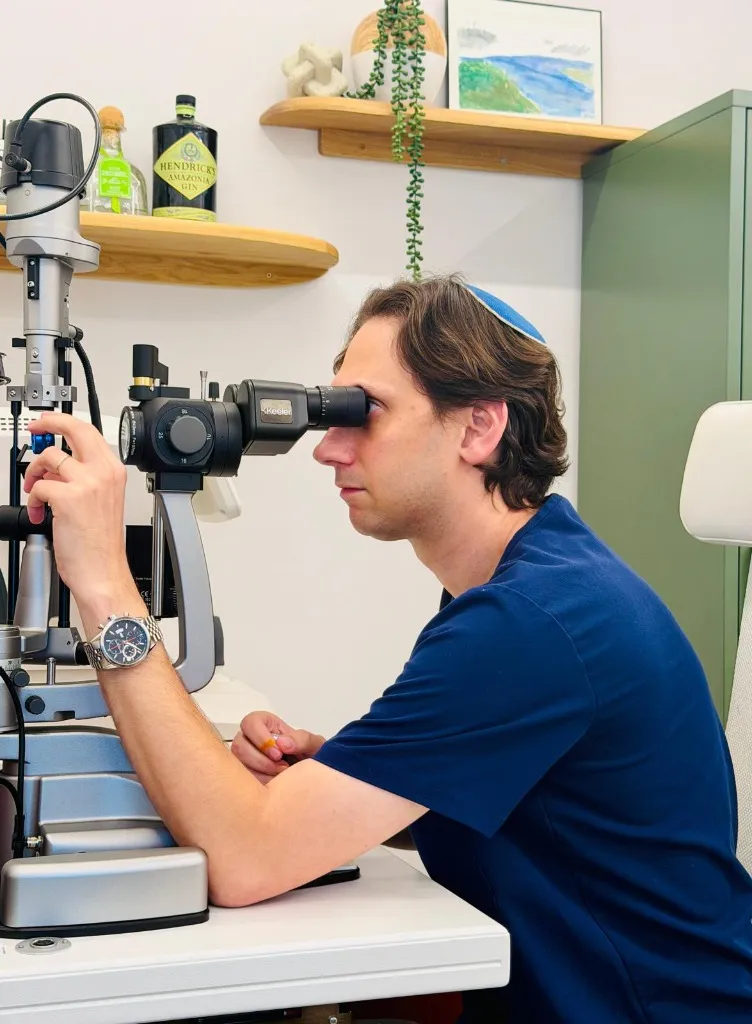 Prof. Ari Leshno examining patient at slit lamp